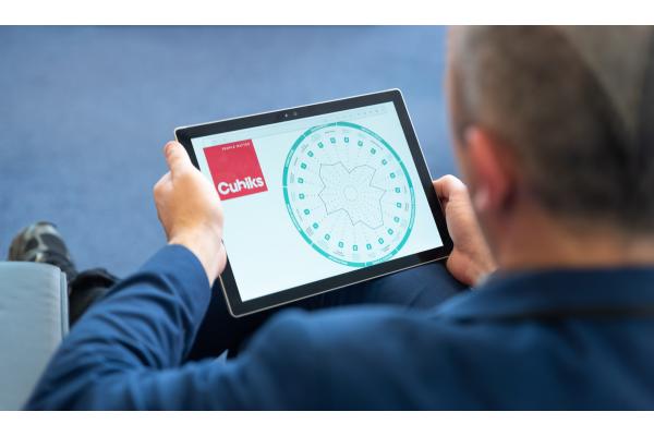 View over a man's shoulder looking at tablet displaying Cubiks PAPI 3 assessment results