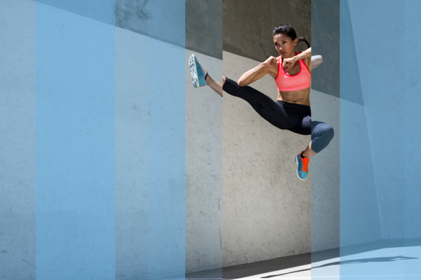 Talented sportswoman doing flying kick