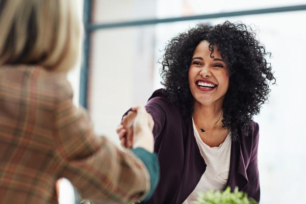 Woman smiling and shaking hands with interviewer
